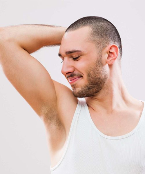 The young man is smelling his armpit after shower | Gladiator Health MD in Riverdale, UT